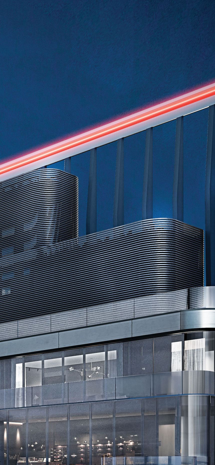 Modern glass building with a sleek facade and a prominent red illuminated roofline.